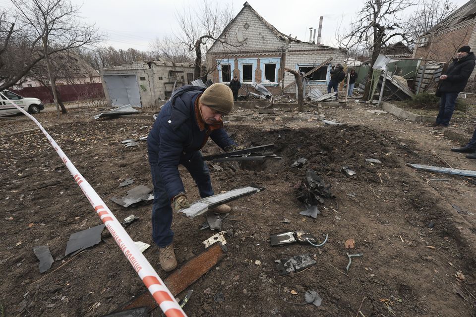 A police forensic expert inspects fragments of a Shahed drone, after a Russian strike on residential neighbourhood in Zaporizhzhia, Ukraine (Kateryna Klochko/AP)