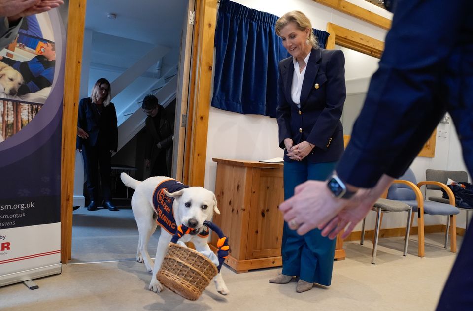 Assistance dog Buddy presents a gift basket to the Duchess of Edinburgh (Andrew Matthews/PA)