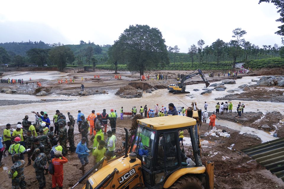 Rescuers use machinery to sift through debris (Rafiq Maqbool/AP)