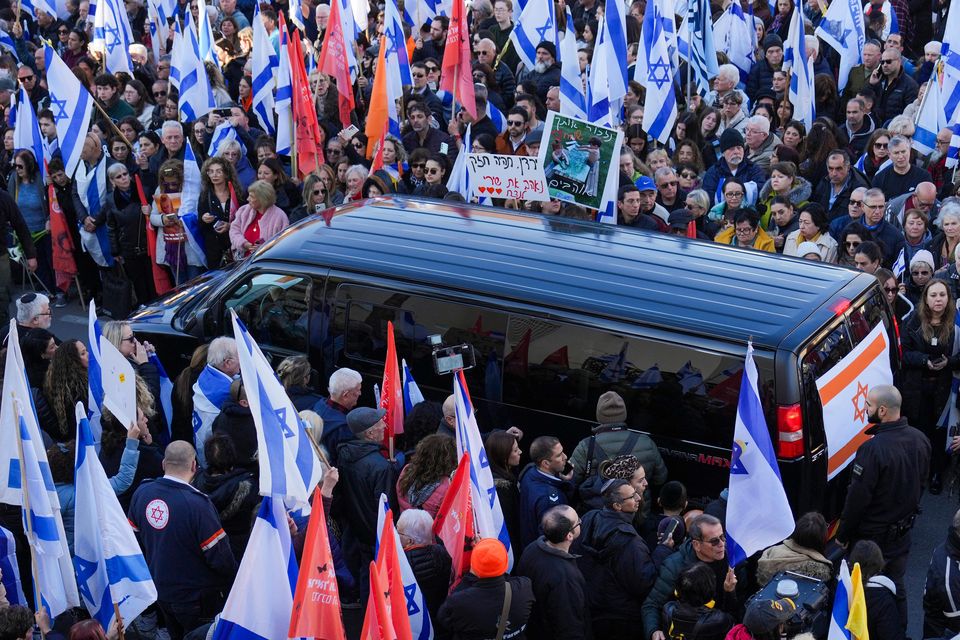 Mourners gather around the convoy carrying the coffins of slain hostages Shiri Bibas and her two children, Ariel and Kfir (AP)