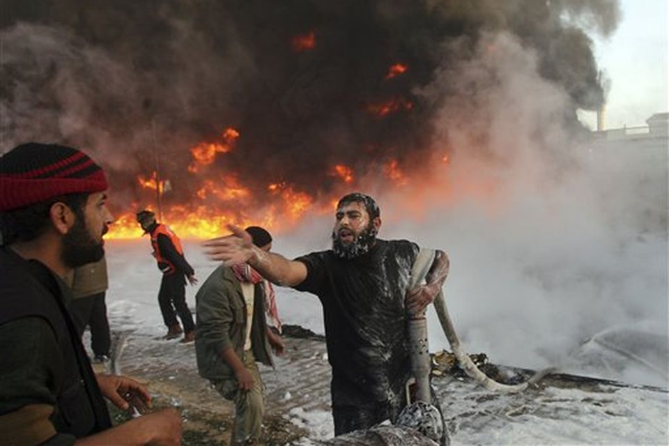Palestinian firefighters try to extinguish fire at a burning building after an Israeli missile strike in the Rafah refugee camp, southern Gaza Strip, Sunday, Dec. 28, 2008. Israeli warplanes pressing one of Israel's deadliest assaults ever on Palestinian militants dropped bombs and missiles on a top security installation and dozens of other targets across Hamas-ruled Gaza on Sunday. Israel's Cabinet authorized a callup of at least 6,500 reserve soldiers, suggesting plans to expand an offensive against Gaza rocket squads that has already killed some 280 Palestinians. (AP Photo/Eyad Baba)