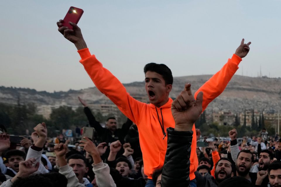 In public squares, many people were still celebrating. Civilian traffic resumed, but there was no public transport (Hussein Malla/PA)