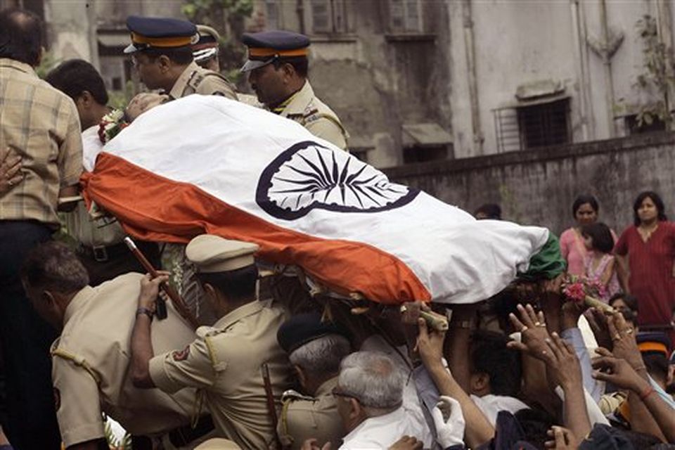 The body of Hemant Karkare, the chief of Mumbai's Anti-Terrorist Squad, who was killed by gunmen, is seen covered in National flag during the funeral procession in Mumbai, India, Saturday, Nov. 29, 2008. Indian commandos killed the last remaining gunmen holed up at a luxury Mumbai hotel Saturday, ending a 60-hour rampage through India's financial capital by suspected Islamic militants that killed people and rocked the nation. (AP Photo/Rajanish Kakade)