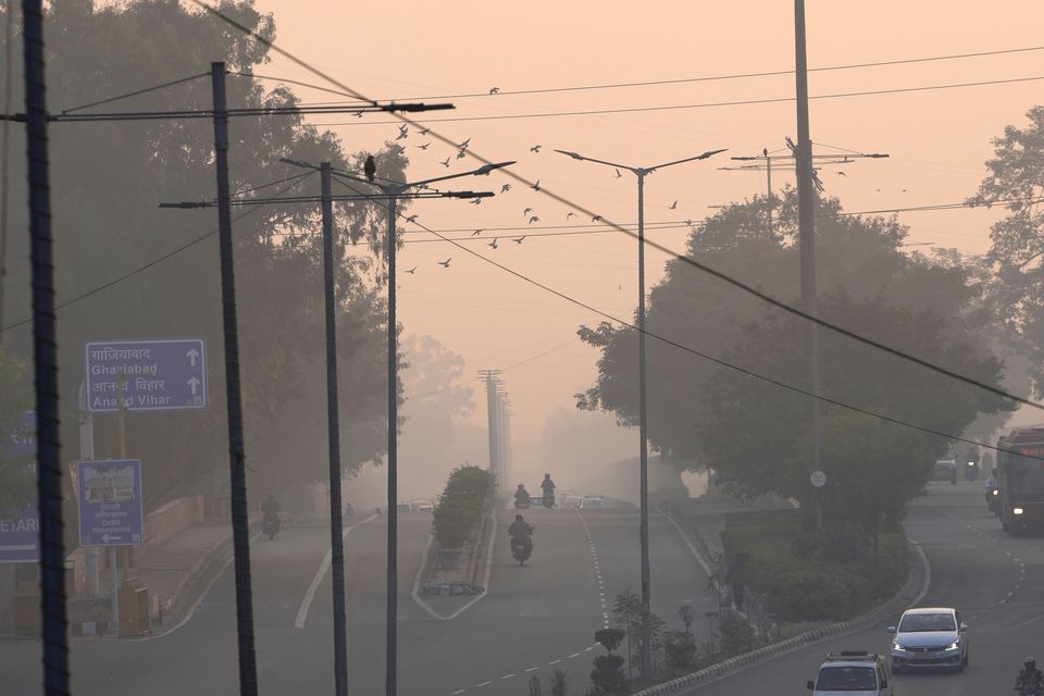 People commute in the early morning smog (Manish Swarup/AP)