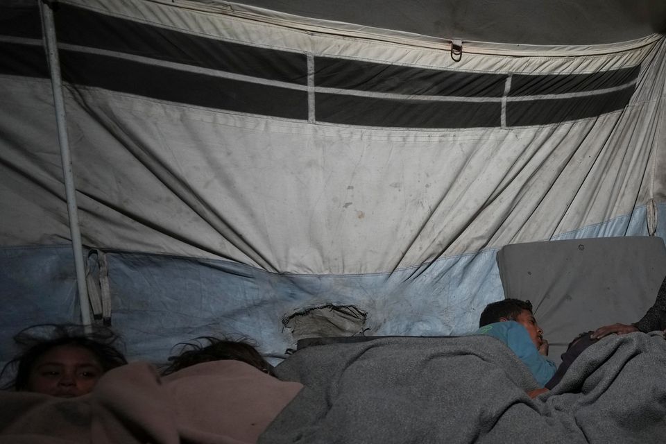 A mother watches over her children in their tent at a camp for displaced people in Deir al-Balah, Gaza Strip (Abdel Kareem Hana/AP)