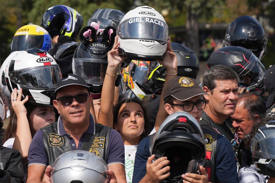 Faithful hold up their helmets to be blessed in Fatima, Portugal (Ana Brigida/AP)