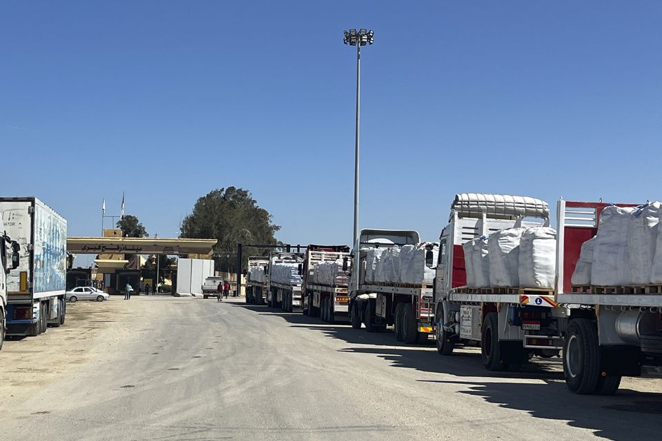 Trucks line up at the Egyptian side of the Rafah border crossing between Egypt and the Gaza Strip (Mohamed Arafat/AP)