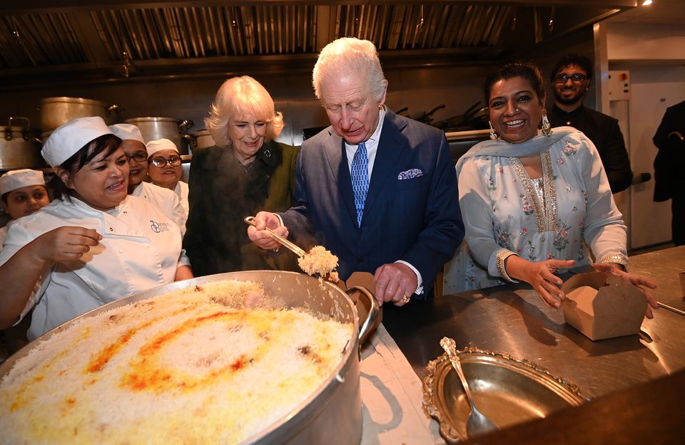 Charles and Camilla help pack donation boxes with head chef Asha Pradhan and owner Asma Khan, at Darjeeling Express in London (Eddie Mulholland/DailyTelegraph/PA)