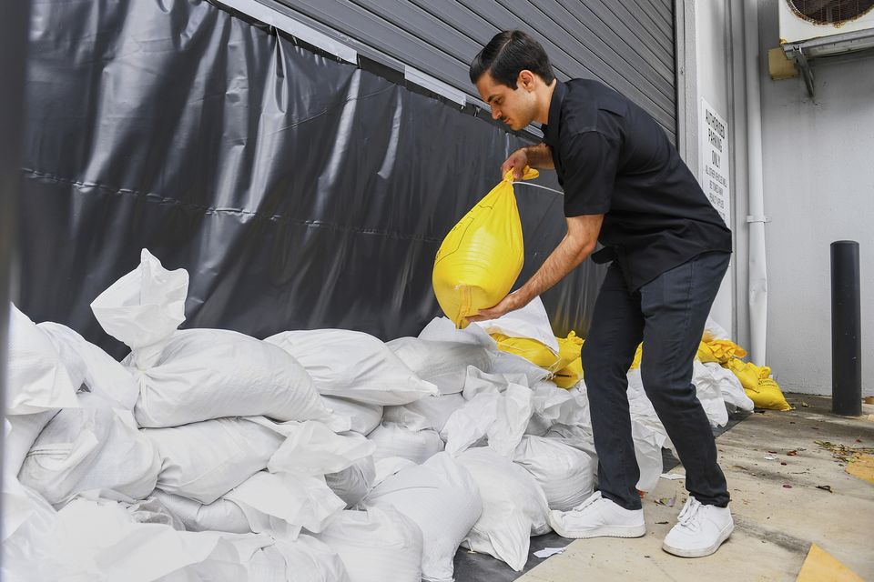 A worker installs sandbags at an engineering business in Brisbane (Jono Searle/AAP Image/AP)