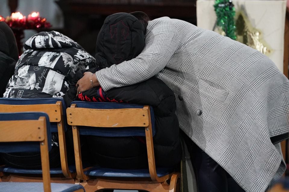 People hug during a vigil at St Mary Magdalene church (Lucy North/PA)