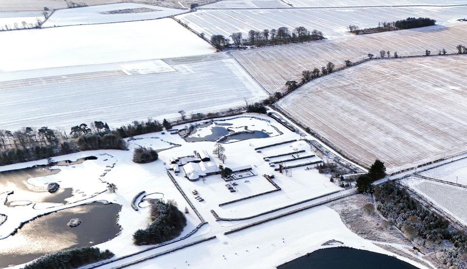 The man-made fish-shaped Muckle Troot Loch near Inverurie, Aberdeenshire, is surrounded by snow and ice as temperatures fall in November (Jane Barlow/PA)