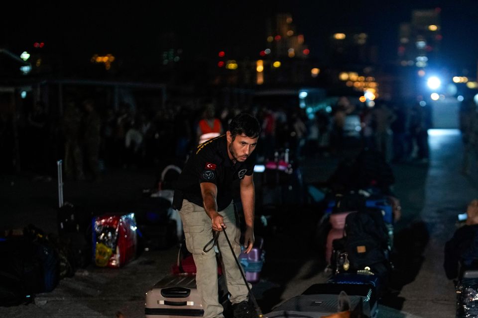 An explosives detection dog inspects luggage of Turkish citizens being prepared to be evacuated (Emrah Gurel/PA)