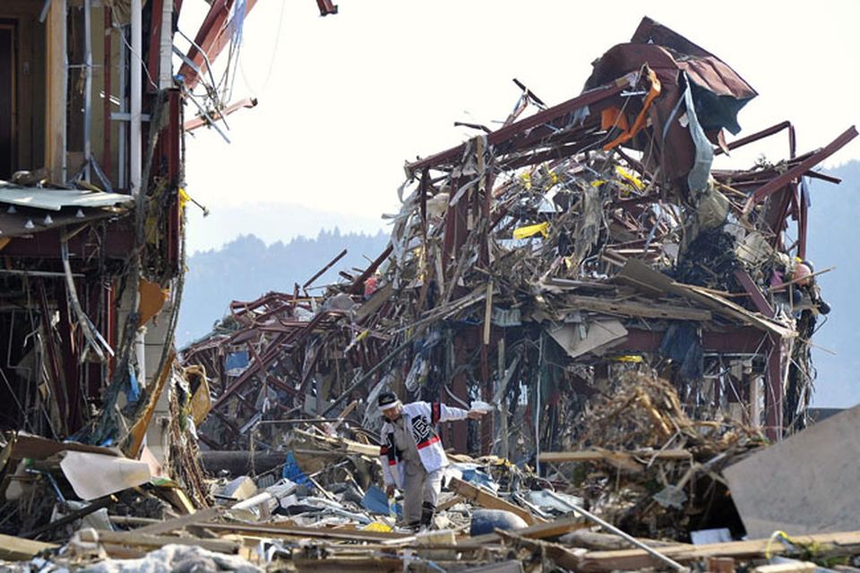A man walks amid the rubble in Minamisanriku town, Iwate prefecture, northern Japan, Sunday, March 13, 2011, two days after a powerful earthquake and tsunami hit the country's east coast. (AP Photo/Kyodo News) JAPAN OUT, MANDATORY CREDIT, NO SALES IN CHINA, HONG  KONG, JAPAN, SOUTH KOREA AND FRANCE