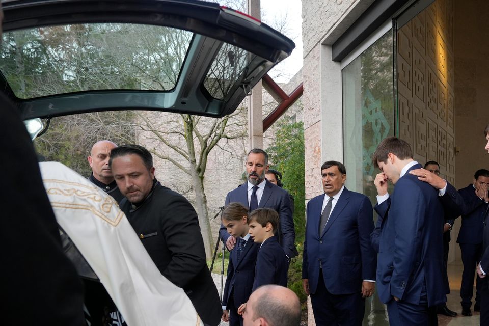 Prince Rahim Al-Hussaini watches with his children as the coffin is placed in a hearse (Ana Brigida/AP)