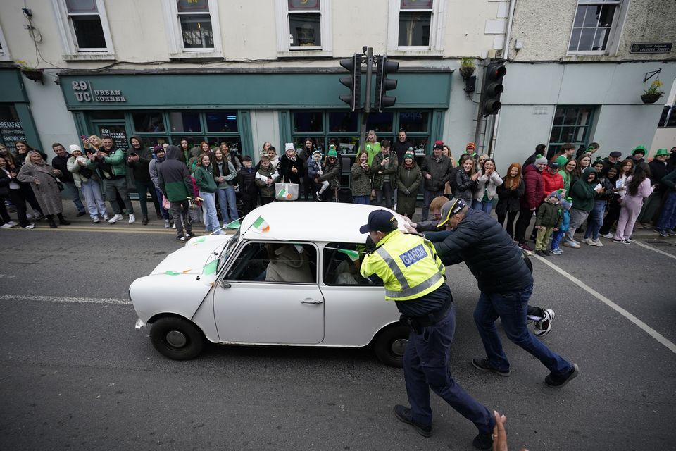 A broken-down Mini is pushed during the St Patrick’s Day Parade in Athy (Niall Carson/PA)