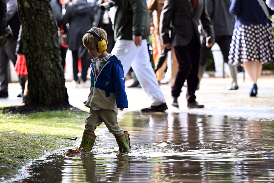 A young race goer in a puddle (John Nguyen/PA)