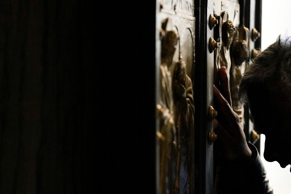 A man stops in prayer as he walks through the Holy Door (AP Photo/Andrew Medichini)