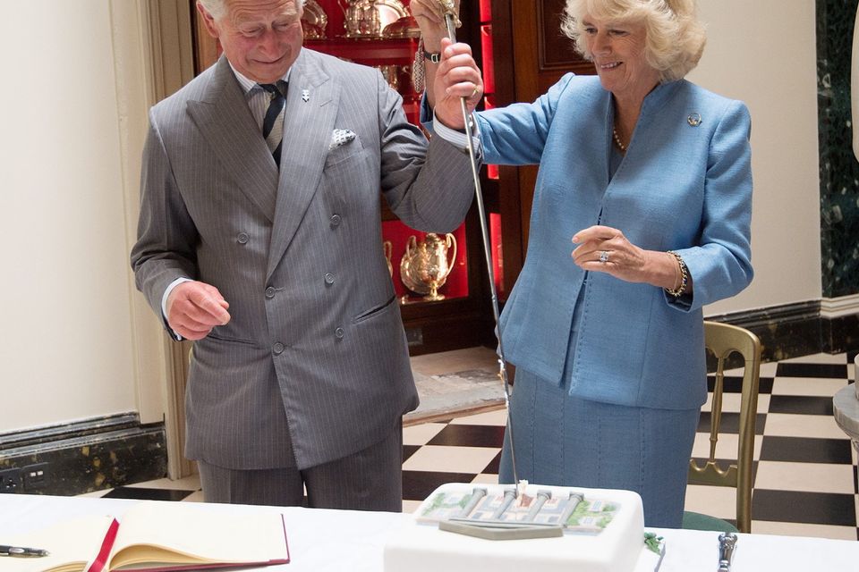 ANTRIM, NORTHERN IRELAND - MAY 22:  Prince Charles, Prince of Wales and Camilla, Duchess of Cornwall cut a cake with the help of Mr David Lindsay, HM Lord-Lieutenant of County Down during their visit to Mount Stewart House and Garden on May 22, 2015 in Newtownards, Northern Ireland. Prince Charles, Prince of Wales and Camilla, Duchess of Cornwall visited Mount Stewart House and Gardens and Northern Ireland's oldest peace and reconciliation centre Corrymeela on the final day of their visit of Ireland.  (Photo by Eddie Mulholland - Pool/Getty Images)