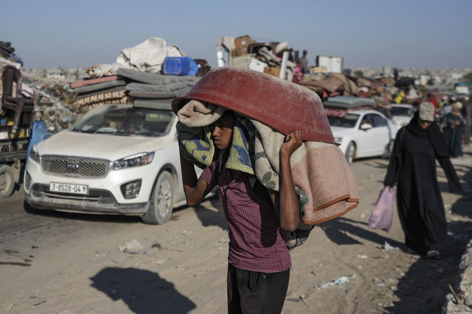 A Palestinian youth flees the Khan Younis area of the Gaza Strip following Israeli military evacuation orders (Abdel Kareem Hana/AP)