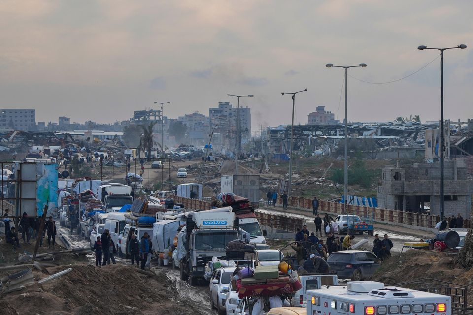 Displaced Palestinians wait at a security checkpoint in the Netzarim corridor while travelling from central Gaza to their homes in the northern Gaza Strip (Abdel Kareem Hana/AP)