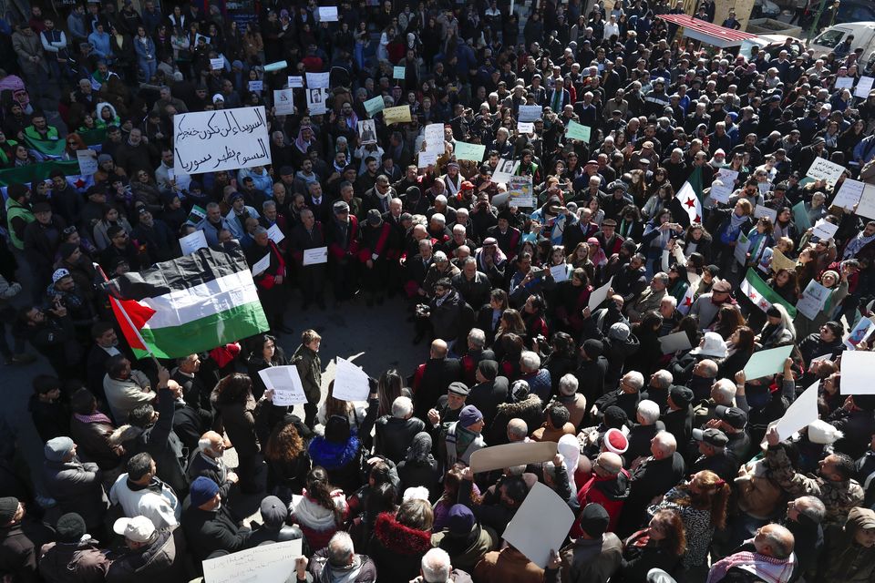 Syrian Druze hold up a placard in Arabic reading ‘Sweida will not be your poisoned dagger in Syria’s back’ at a demonstration against Israeli incursions into Syrian territory in the southern province of Sweida (Omar Sanadiki/AP)