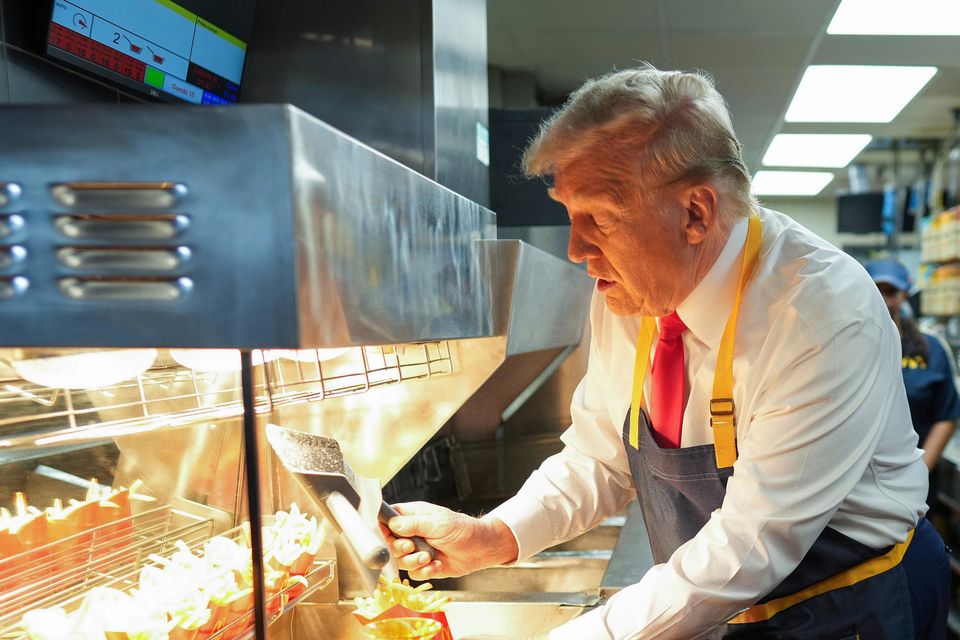 Donald Trump serves fries as an employee watches (Doug Mills/The New York Times/AP/Pool)