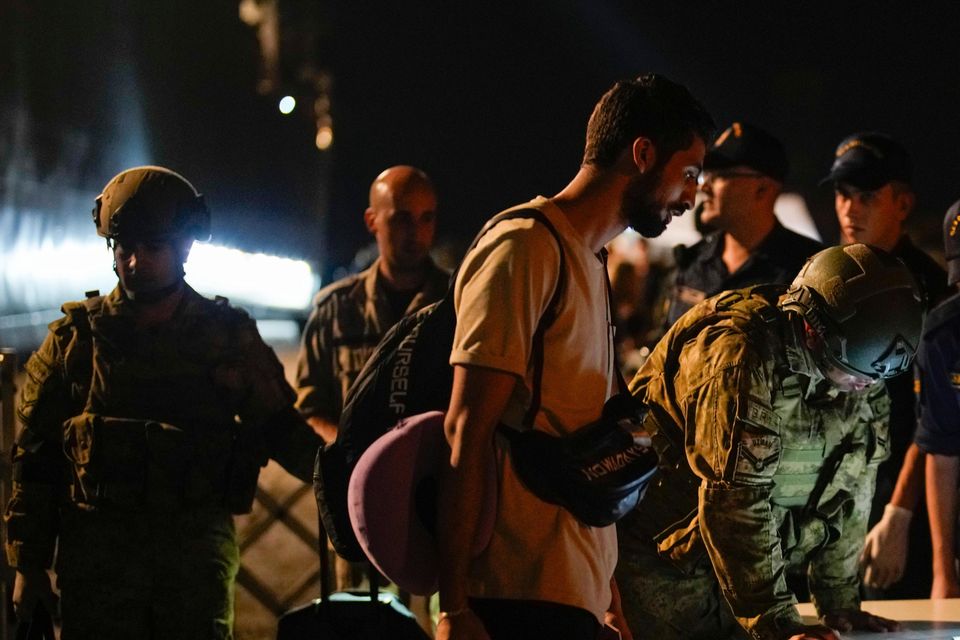 Turkish security officials verify the travel documents of citizens before boarding Turkish military ships to evacuate them from Lebanon to Turkey in Beirut port (Emrah Gurel/AP)