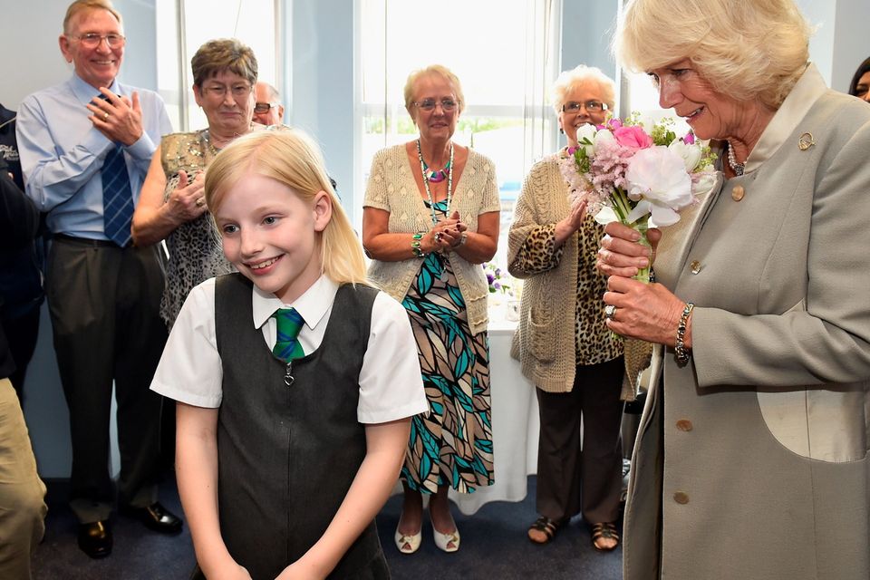 The Duchess of Cornwall receives flowers from Sophie Booker,ten, as she visits Ballyhackamore Credit Union in Belfast, Northern Ireland, as the Prince of Wales and Camilla, attend a series of engagements in Northern Ireland following their two day visit in the Republic of Ireland. PRESS ASSOCIATION Photo. Picture date: Thursday May 21, 2015. See PA story ROYAL Ireland. Photo credit should read: Jeff J Mitchell/PA Wire
