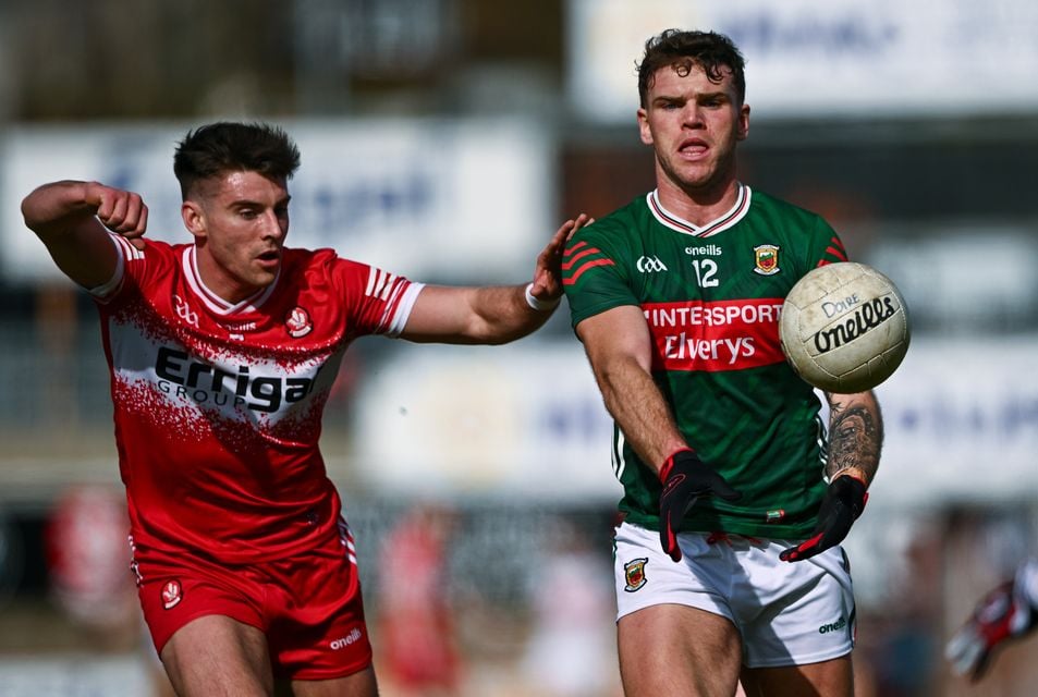 Derry's Conor Doherty looks to apply pressure on Mayo counterpart Jordan Flynn