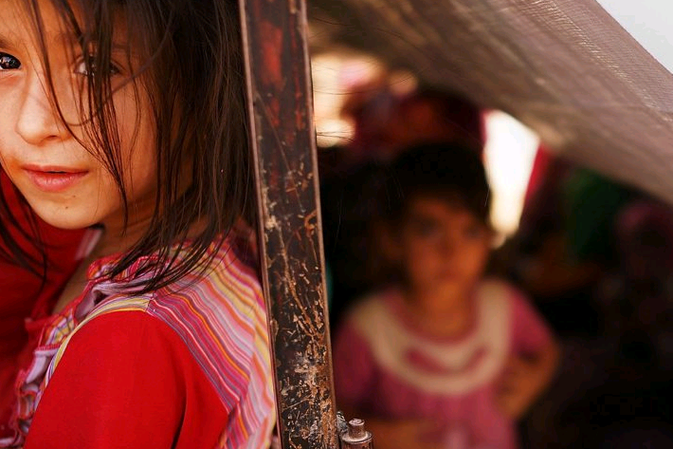 An Iraqi child waits with her family to get into a temporary displacement camp for Iraqis caught-up in the fighting in and around the city of Mosul on June 26, 2014 in Khazair, Iraq. (Photo by Spencer Platt/Getty Images)