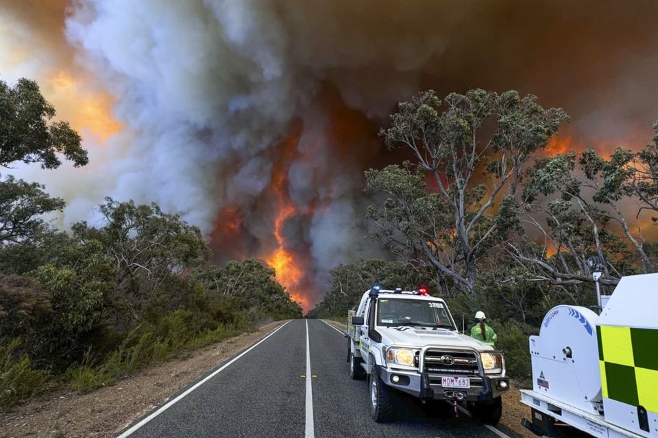 Fire crews watch as smoke billows from an out-of-control bushfire in the Grampians National Park (State Control Centre/AP)