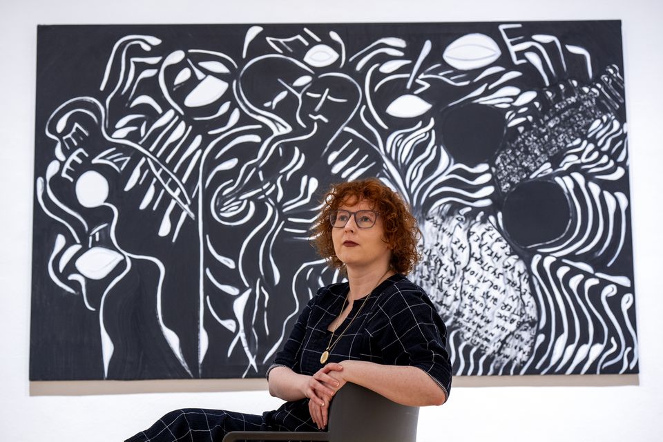 Senior curator Stephanie Straine alongside a 1985 acrylic painting titled Set Free (Jane Barlow/PA)