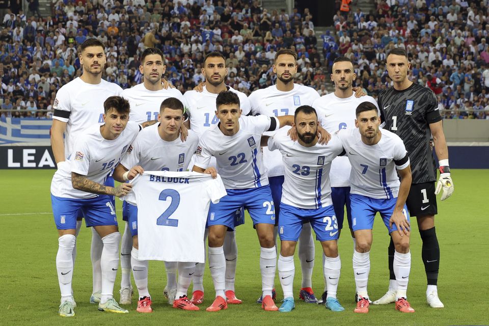 Greece players pose with a shirt of team-mate George Baldock following his death aged 31 (AP Photo/Yorgos Karahalis)