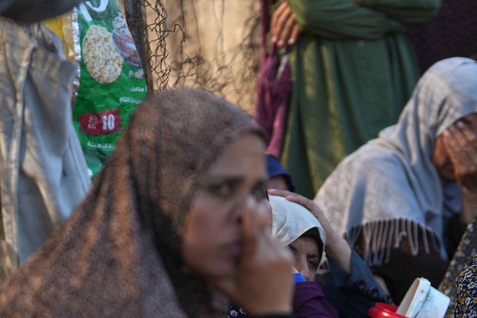 Palestinians queue for food in Deir al-Balah in the Gaza Strip (Abdel Kareem Hana/AP)