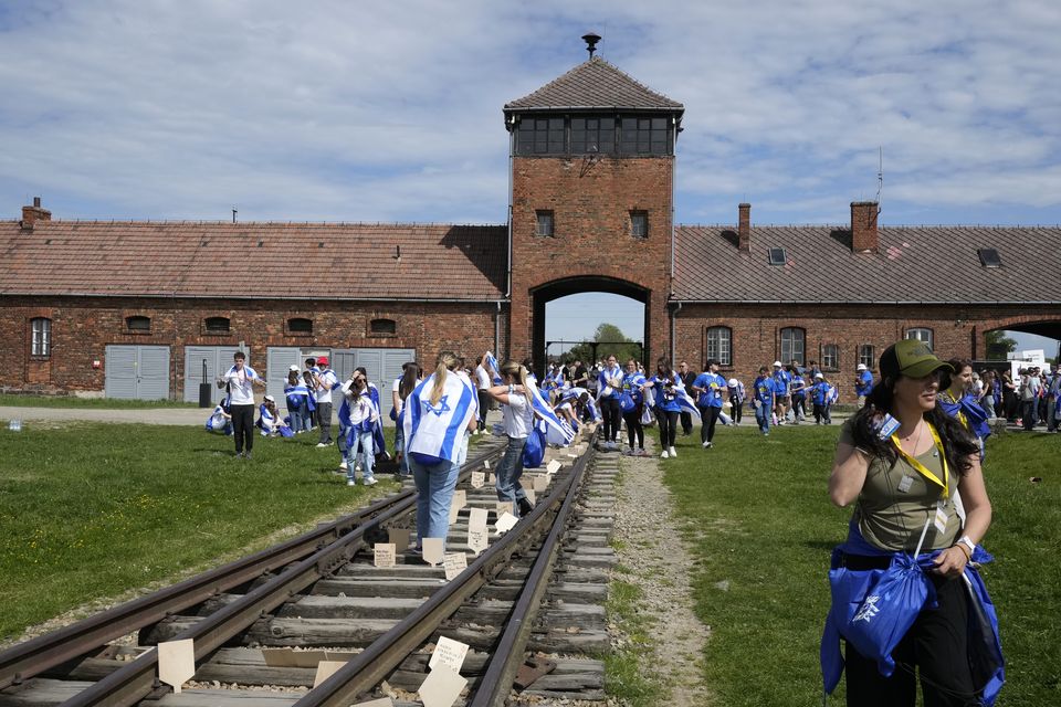 People walk through the former Nazi death camp of Auschwitz-Birkenau (Czarek Sokolowski/AP)