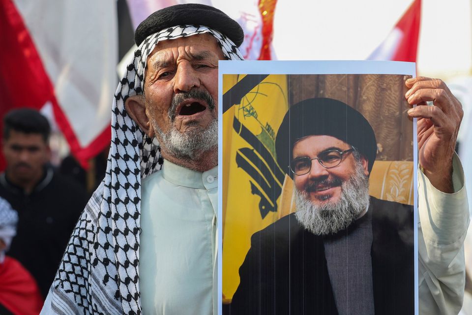 An Iraqi man holds a picture of Hezbollah leader Sayyed Hassan Nasrallah who was killed by an Israeli airstrike in Beirut, during a symbolic funeral in Basra, Iraq, Sunday, Sept. 29, 2024. (AP Photo/Nabil al-Jourani)