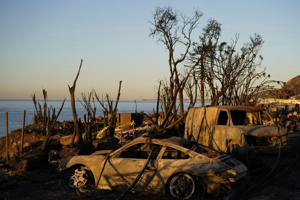 Charred vehicles sit along the Pacific Coast Highway in Malibu, California (Carolyn Kaster/AP)