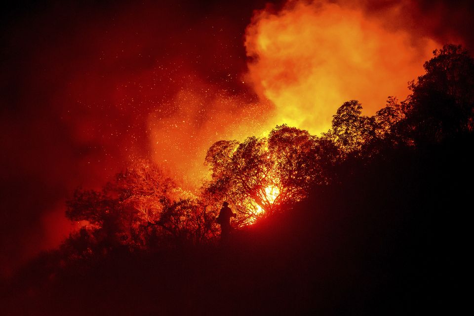 A firefighter battles the Lilac Fire near the Bonsall community of San Diego (Noah Berger/AP)