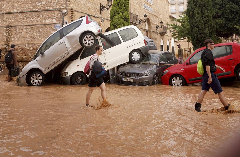 Residents walk through flooded streets in Valencia,(Alberto Saiz/AP)