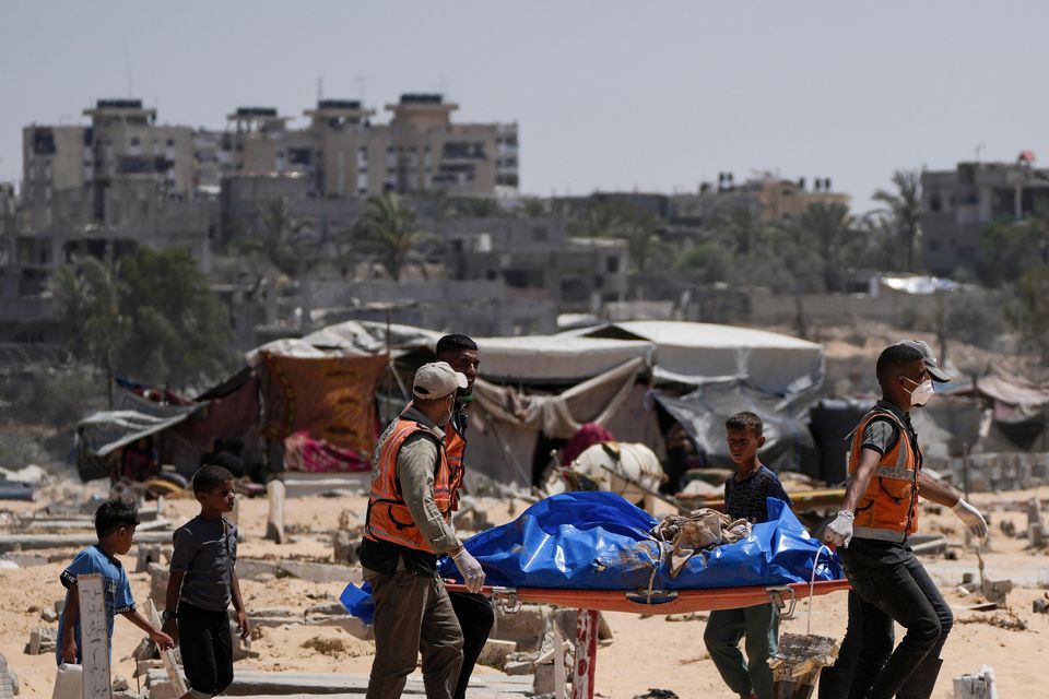 Workers carry a body to a cemetery in Khan Younis, Gaza Strip (Abdel Kareem Hana/AP)