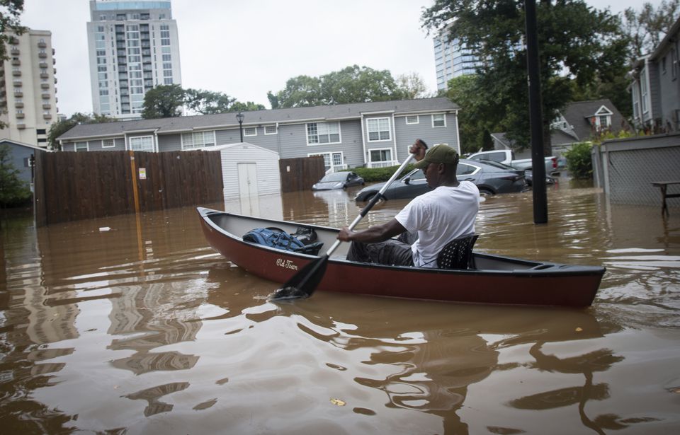 An unidentified man paddles a canoe to rescue residents and their belongings at a flooded apartment complex in Atlanta (Ron Harris/AP)