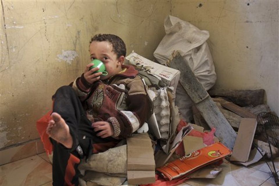 Fares al-Dali drinks tea as he sits on a pile of wood and cartons in a house in the Shati refugee camp in Gaza City, Monday, Jan. 12, 2009. In the al-Dali family's two-room shack in the Shati refugee camp, 21 people _ half of them relatives who fled the fighting _ take turns sleeping because the family doesn't have enough mattresses. For lack of fuel, they cook on trash fires _ paper and cartons collected in the neighborhood. (AP Photo/Adel Hana)