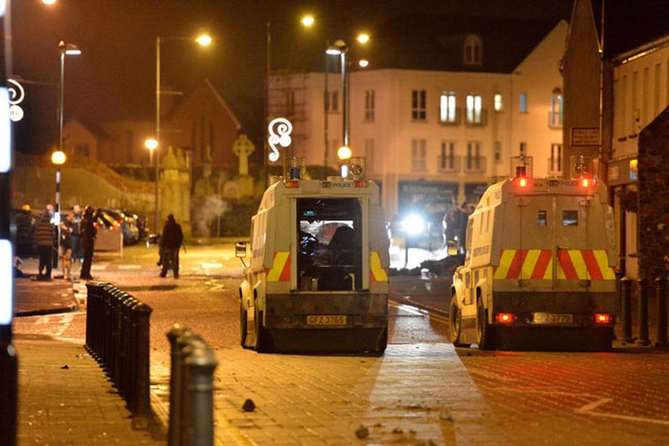 Police in Carrick come under attack from protestors following a fire at the  Alliance party office