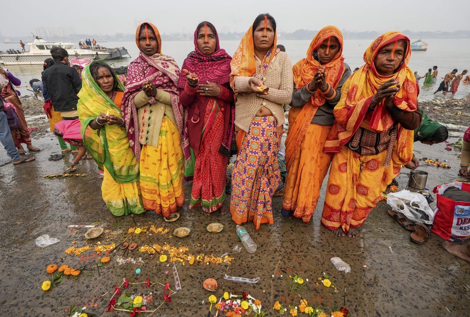 Hindu pilgrims perform rituals after taking a holy dip in the Hooghly River in Kolkata, India (Bikas Das?AP)