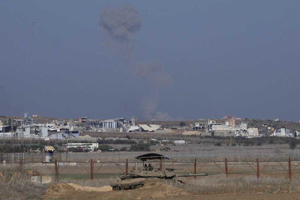 An Israeli tank sits on the Israeli-Gaza border, with a cloud of smoke inside the Gaza Strip in the background (Matias Delacroix/AP)