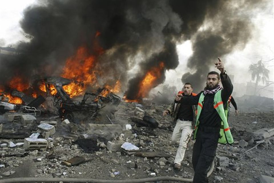 Palestinian firefighters try to assist at the site of a security compound used by the Islamic group Hamas following an Israeli missile strike in Rafah, southern Gaza Strip, Saturday, Dec. 27, 2008. Israeli warplanes demolished dozens of Hamas security compounds across Gaza on Saturday in unprecedented waves of simultaneous air strikes. Gaza medics said more than 120 people were killed and more than 250 wounded.(AP Photo/Hatem Omar)