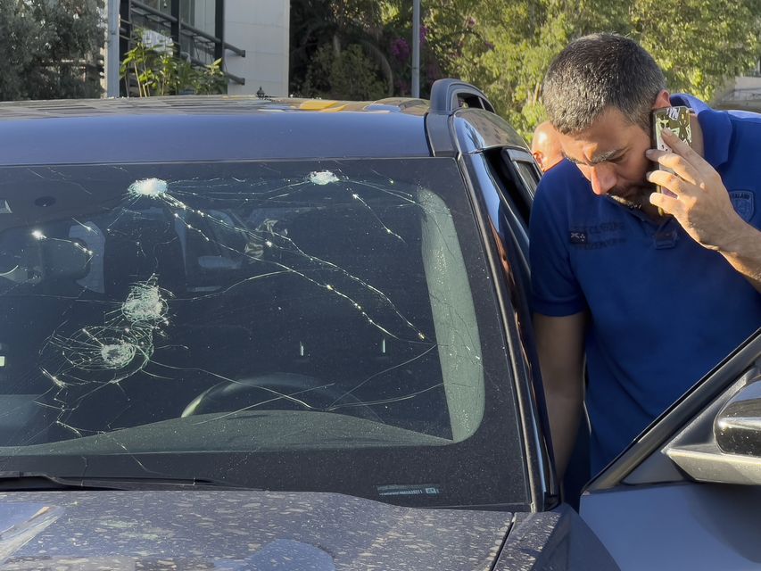 A police officer inspects a car in which a hand-held pager exploded, in Beirut, Lebanon (Hussein Malla/AP)