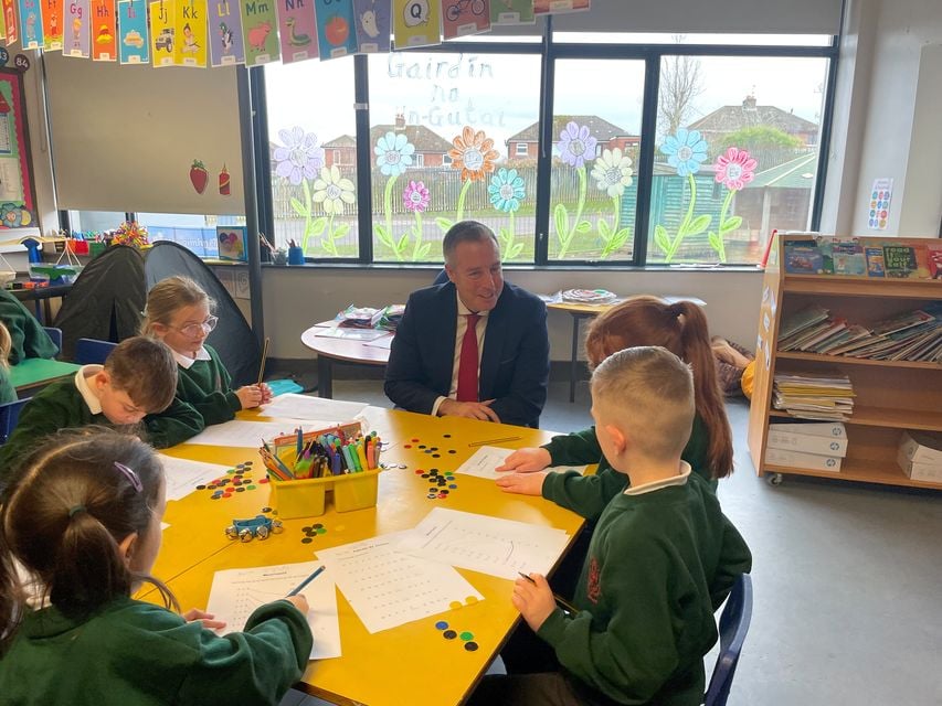 Paul Givan talking to pupils at Bunscoil Phobal Feirste on Wednesday