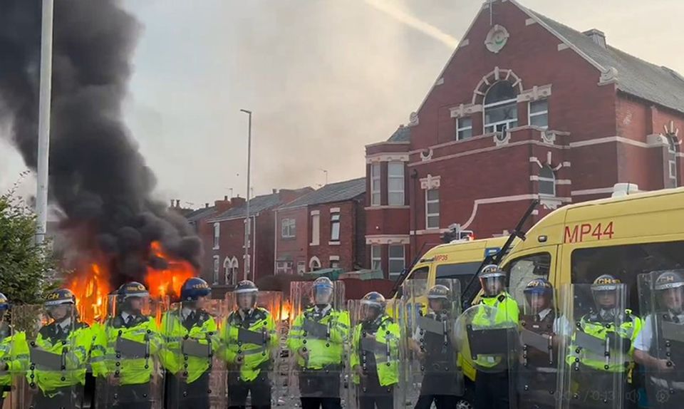 A police van set alight as trouble flares during a protest in Southport (Pat Hurst/PA)