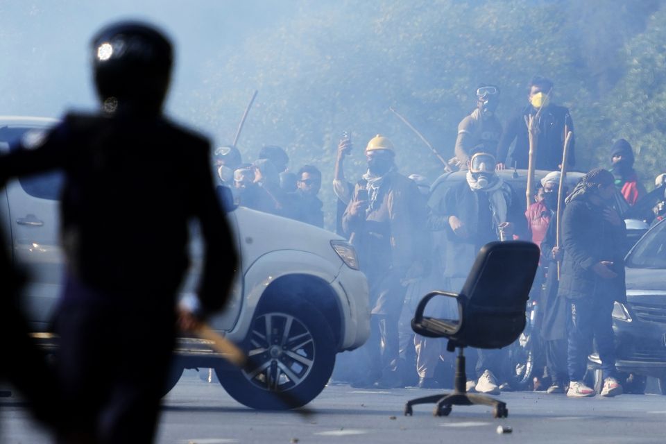 Supporters of jailed former premier Imran Khan’s Pakistan Tehreek-e-Insaf party throw stones towards police during clashes in Islamabad (Anjum Naveed/AP)